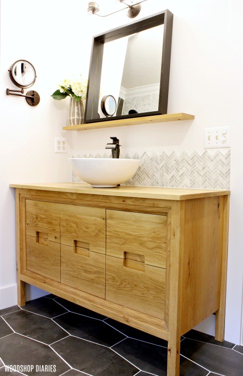 Floating shelf with black framed mirror over modern white oak vanity in modern bathroom remodel