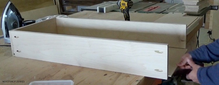 Shara installing plywood drawer bottom into dresser drawer box