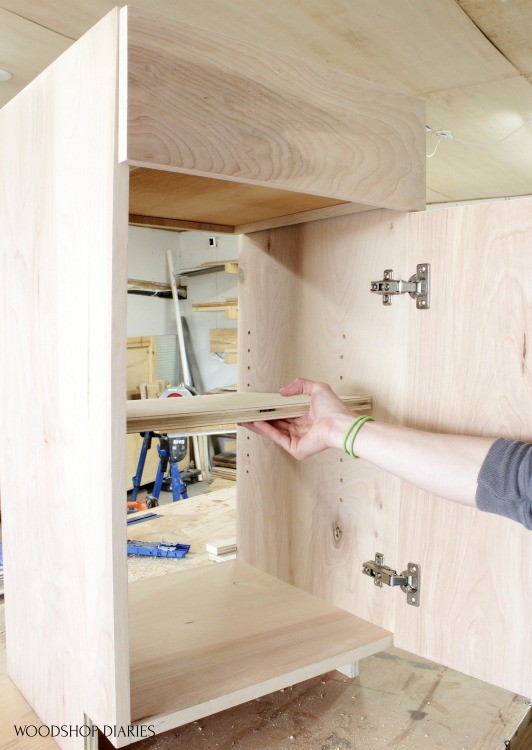 Installing shelves into cabinet on shelf pins
