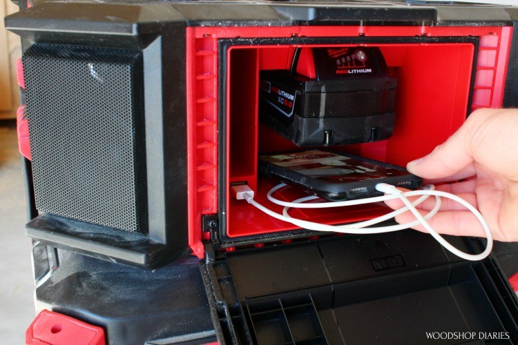 Shara placing phone into weather tight compartment of PACKOUT radio charger