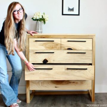 Shara standing next to modern 5 drawer dresser with next to the bottom dresser open