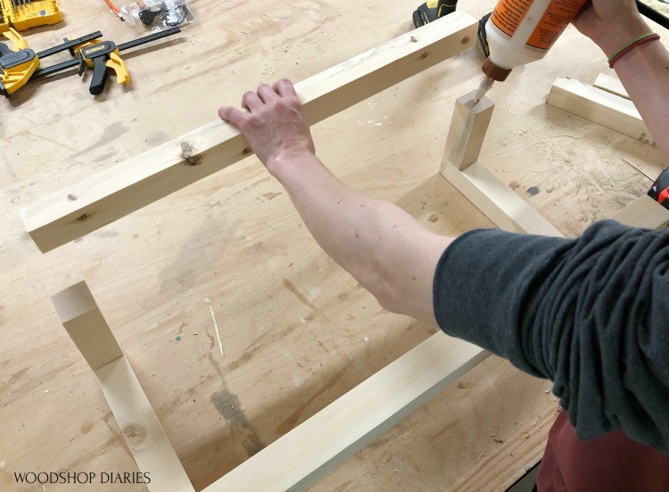 Applying glue to short pieces of scrap wood towel rack on front side