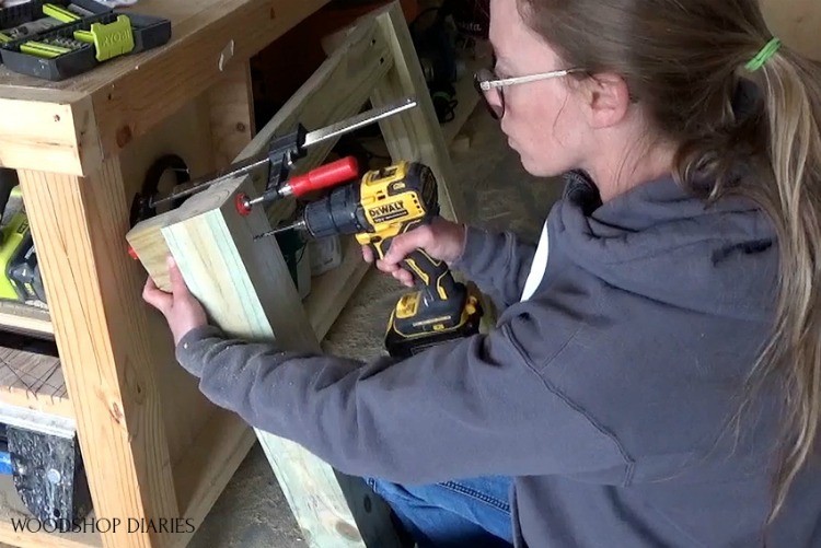 Shara driving 4" wood screws to attach decorative end piece to table ends