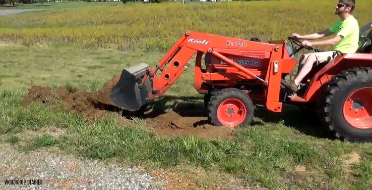 Danny moving dirt with tractor to fill new garden bed