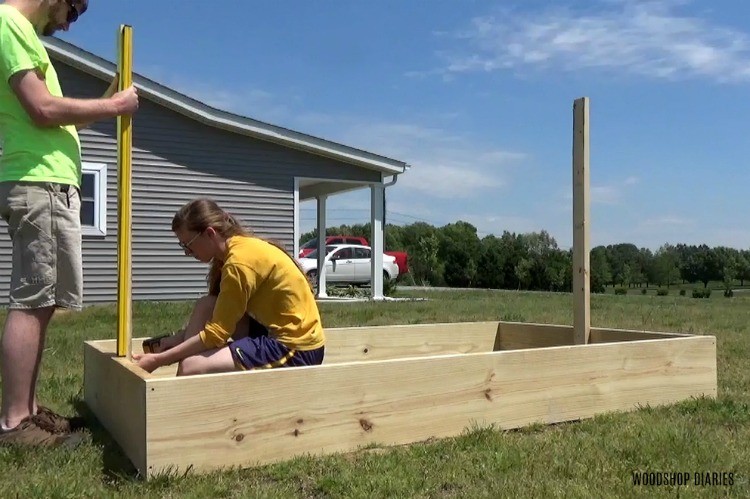 Shara and Danny screwing trellis frame into garden bed