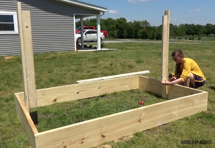 Shara screwing trellis frame into garden bed