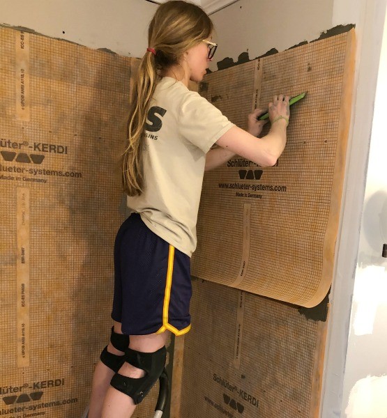 Shara applying Schluter Kerdi to shower walls