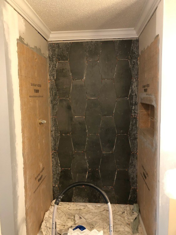 Back shower wall tile installed with small gap at top