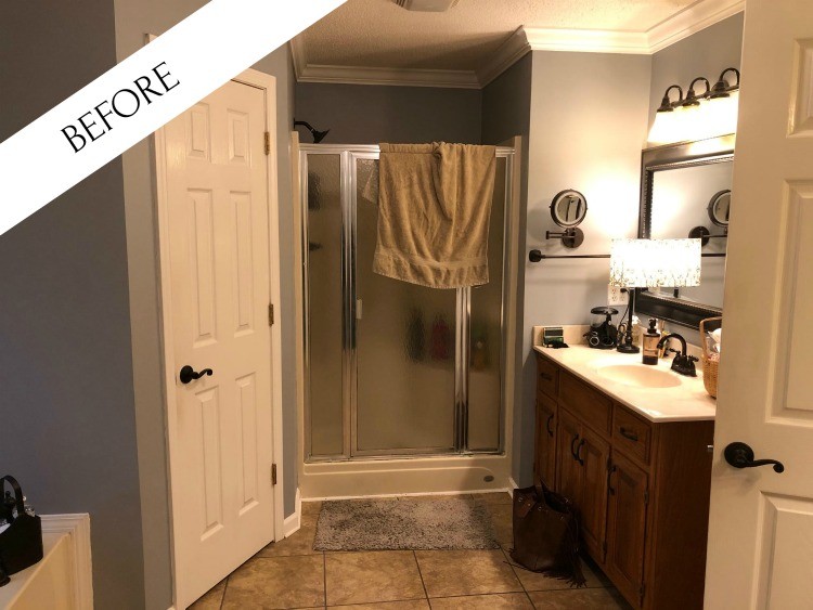 Master Bathroom before--blue walls, dark oak vanity and dark mirror and tan floors