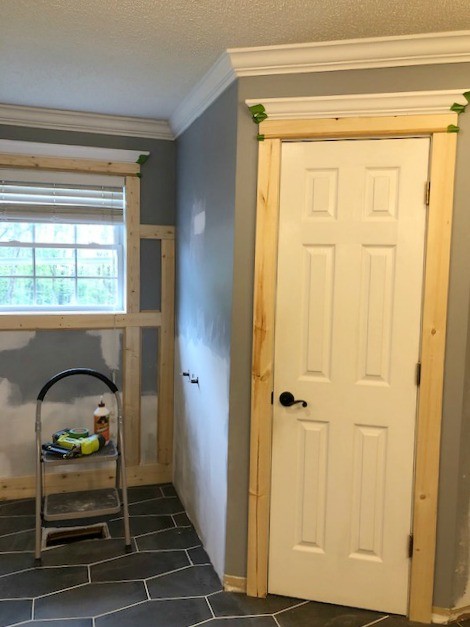 Unfinished door and window trim installed in master bathroom