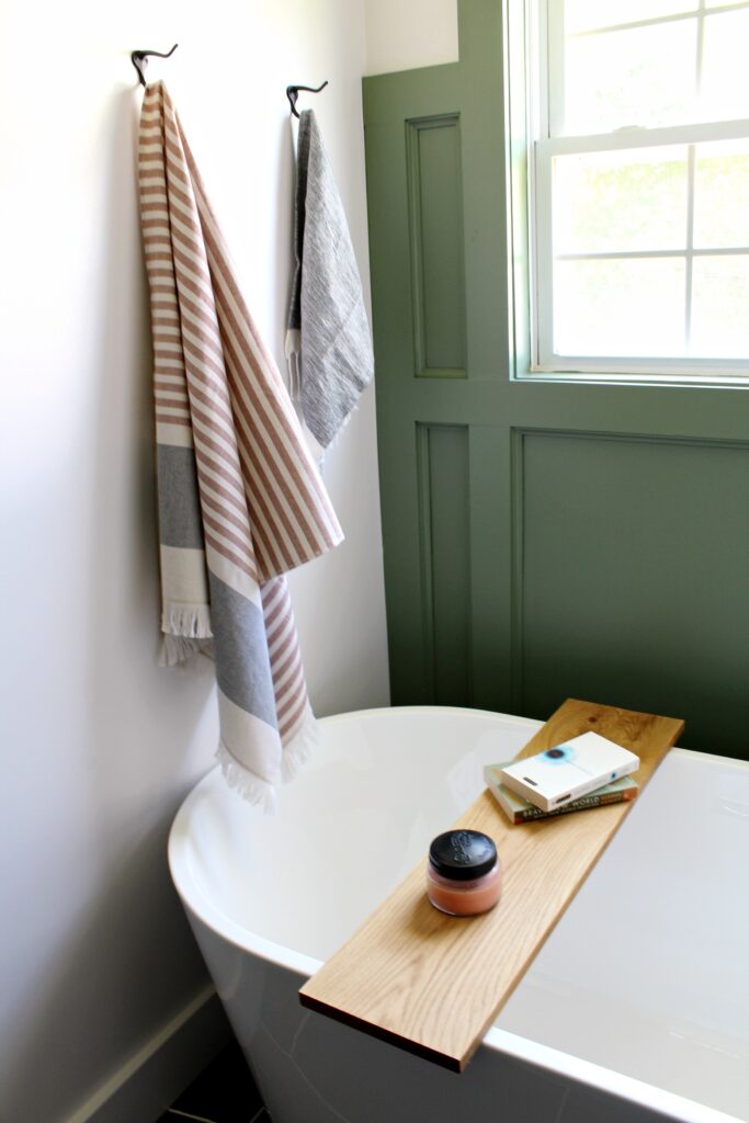 Tub tray laying across top of bathtub in newly remodeled bathroom