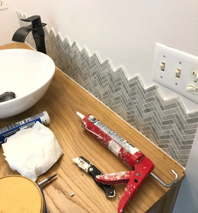 Backsplash installed, grouted, and caulked above vanity