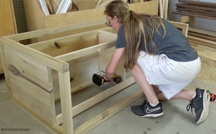 Shara screwing in drawer divider panel into dresser frame