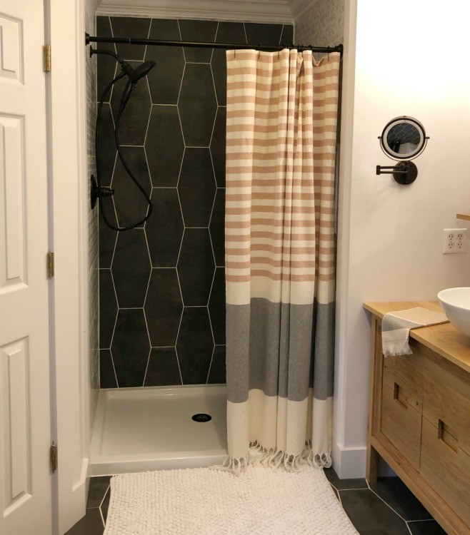 Shower curtain installed in tiled shower nook