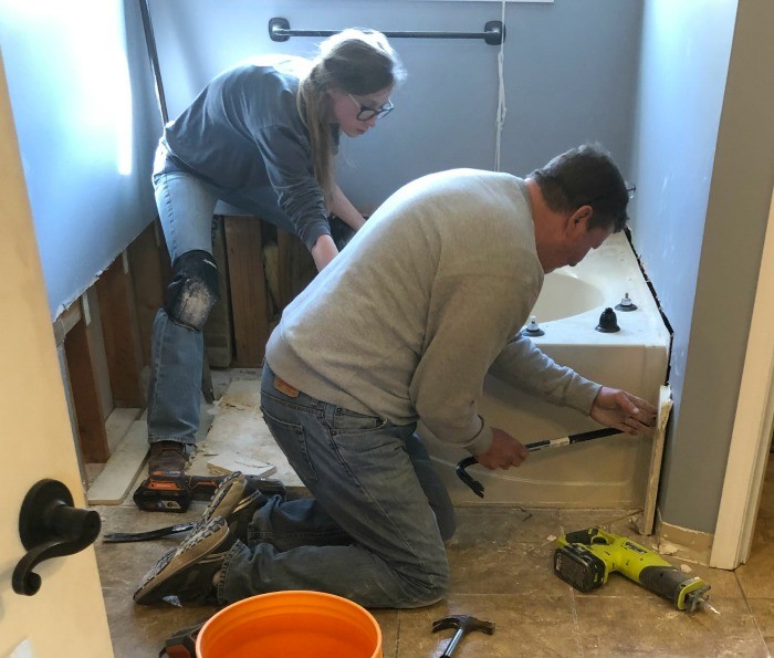 Shara and Dad tearing out bathtub in master bathroom