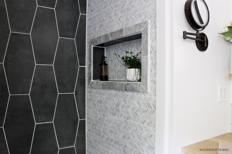 Up close master bathroom shower tile niche with grey framed trim