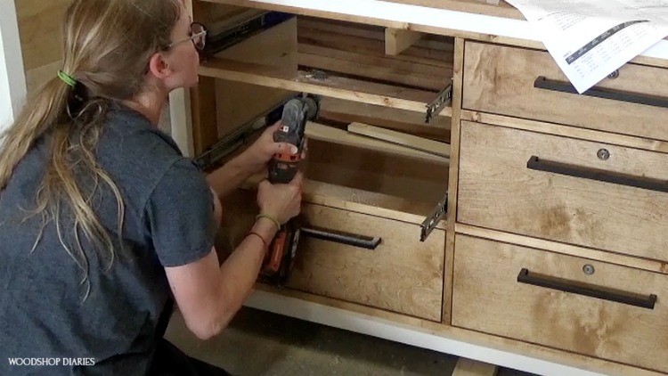 Shara using oscillating saw  to cut slots in dresser frame for lock tab