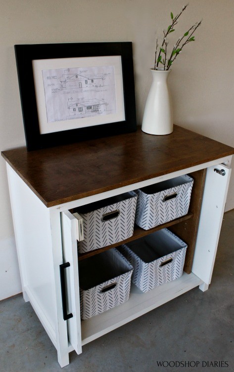 Pocket door cabinet with doors open slid into the cabinet and storage baskets on shelves