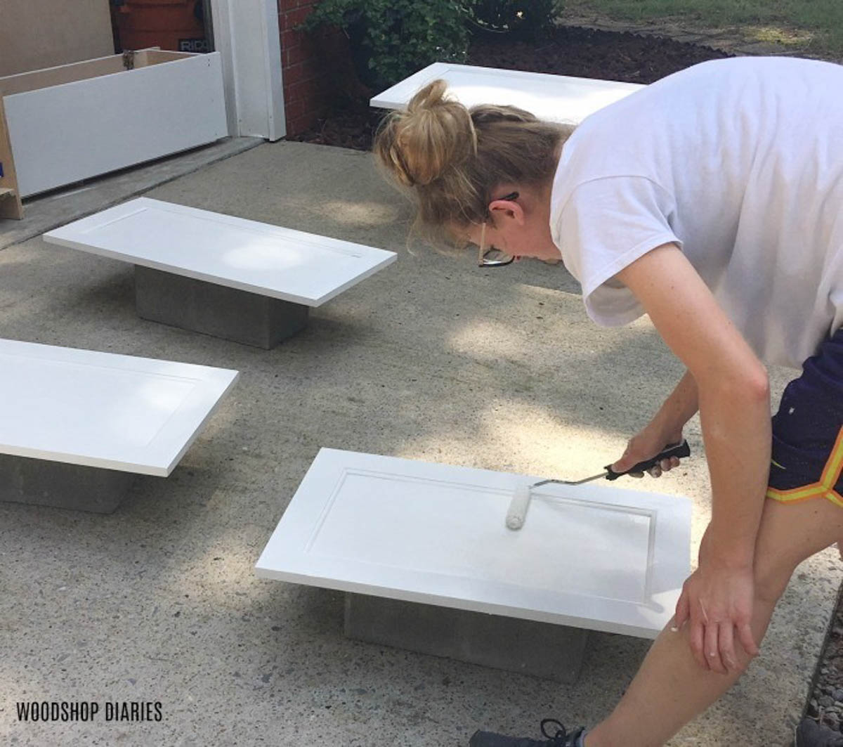Shara rolling primer onto cabinet doors--diy furniture tips--prime before painting raw wood