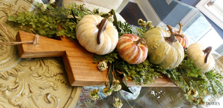 DIY Serving Board used as dining table centerpiece with pumpkins and greenery