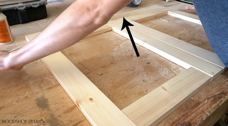 Holding scrap piece to trace out bow to make arched cabinet doors