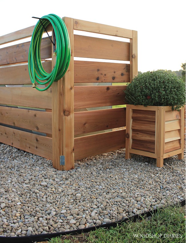 Close up view of simple fence used to hide ugly well house in yard