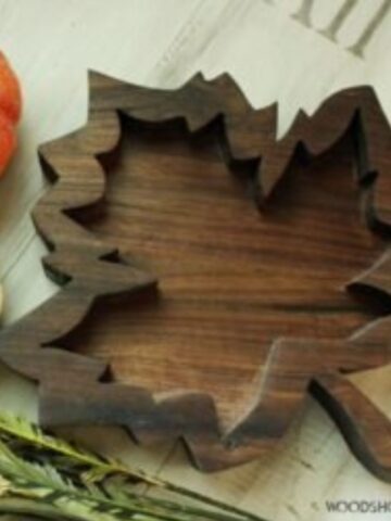 Completed fall tray sitting on coffee table with orange and white pumpkins and fall greenery.