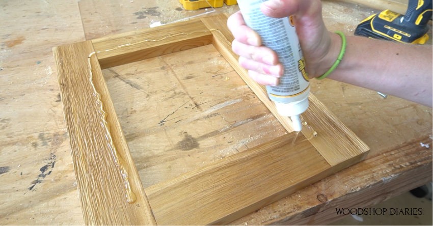 Applying clear gorilla glue to door frame for blessing box