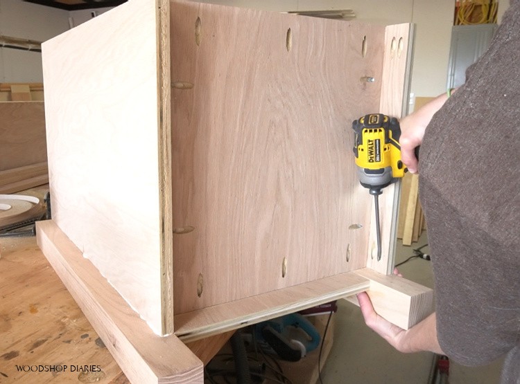 Screwing bottom panel into desk cabinet using pocket hole screws