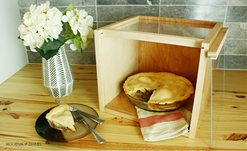 Apple pie in DIY pie carrier display box with front lid removed and a slice cut out