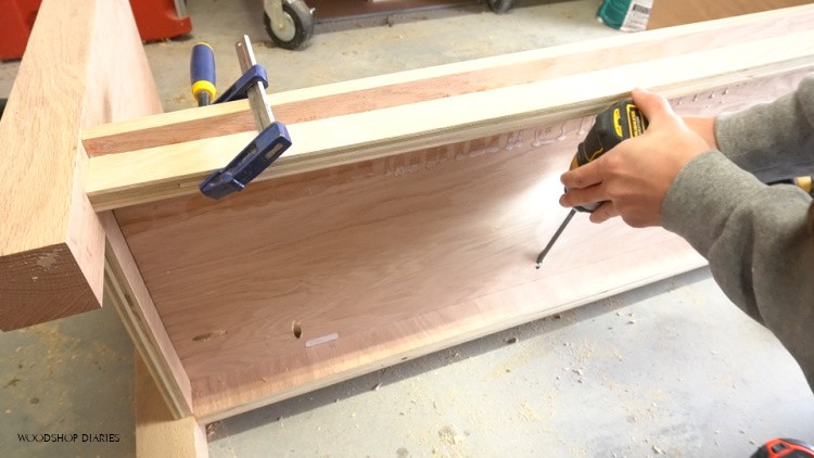 Using pocket holes to screw bottom panel in place in cabinet
