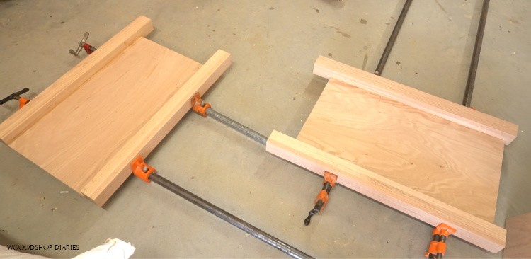 Two L shaped desk side panels glued up in clamps