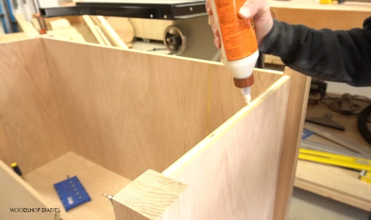Applying glue to glue end boards in place on corners