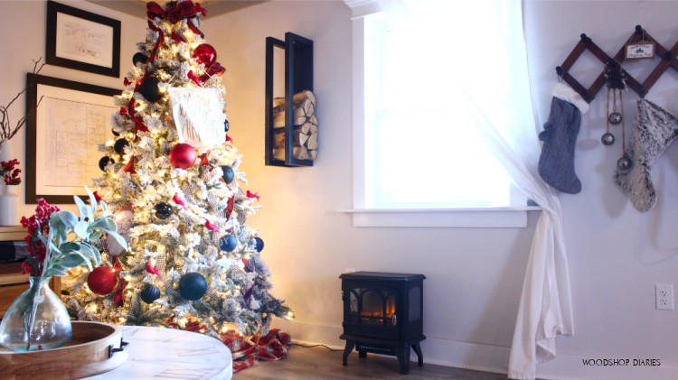 Firewood rack hanging next to Christmas tree above fireplace