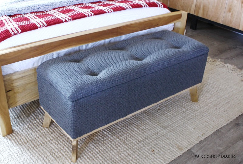 DIY tufted top upholstered storage bench in grey fabric at end of bed