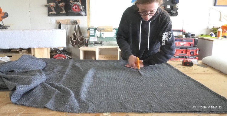 Cutting fabric shower curtain on workbench