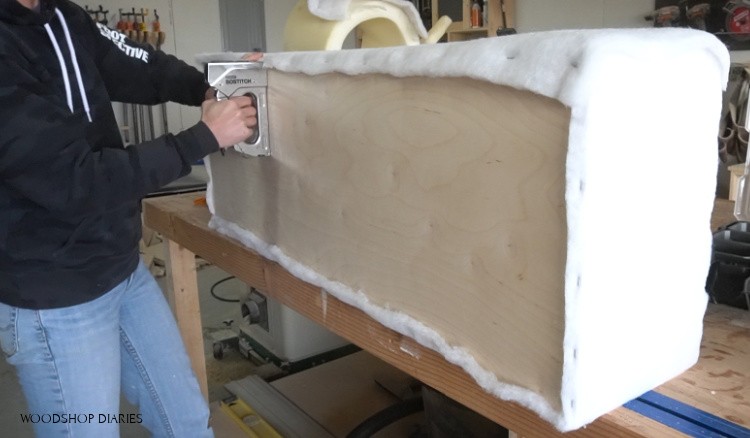 Stapling batting onto bottom of upholstered storage bench