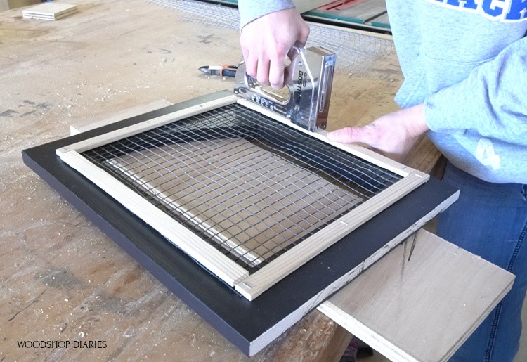 Stapling thin trim strips onto back of door to cover rough edges