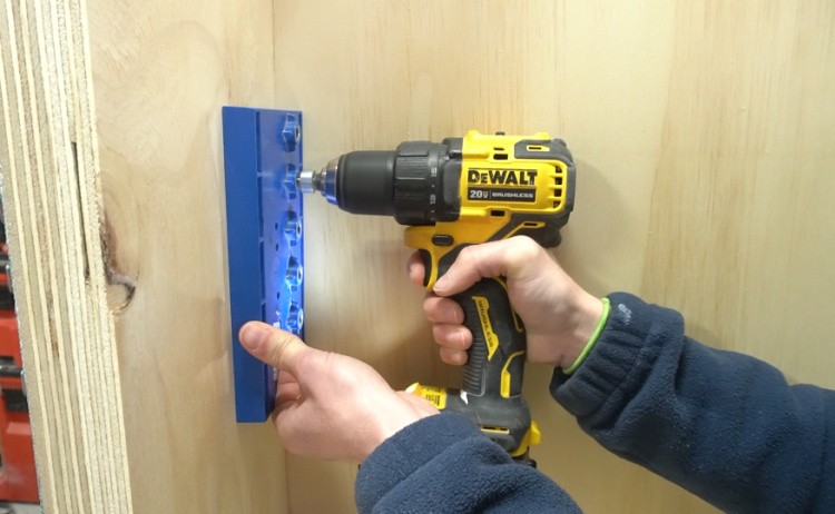 Using shelf pin jig to drill holes into cabinet sides