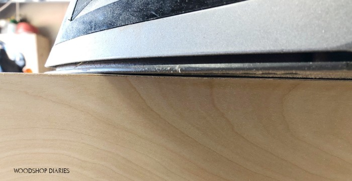 Close up of iron melting glue on plywood edge banding