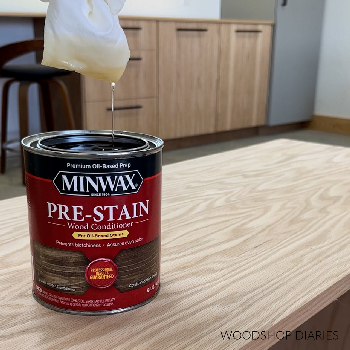 rag dipped in Minwax prestain dripping into can