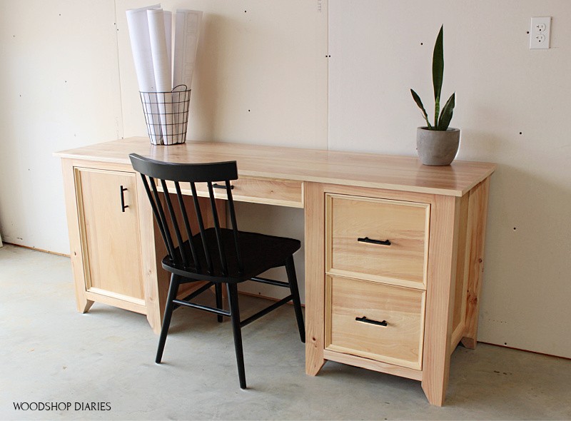 Finished DIY computer desk with two drawers on right, keyboard tray in center and door on left