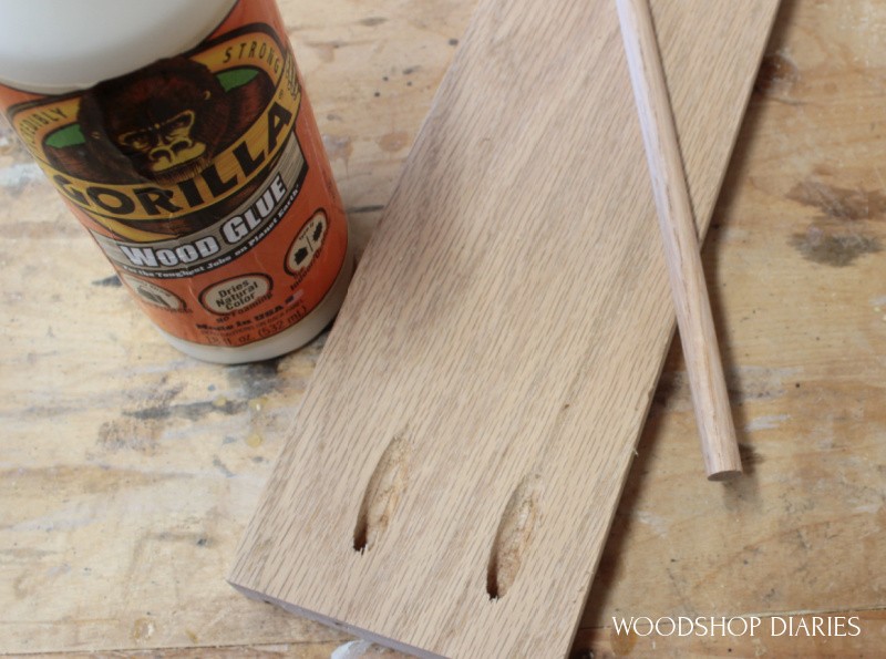 Pocket holes drilled in end of oak board with oak dowel rod lying on top