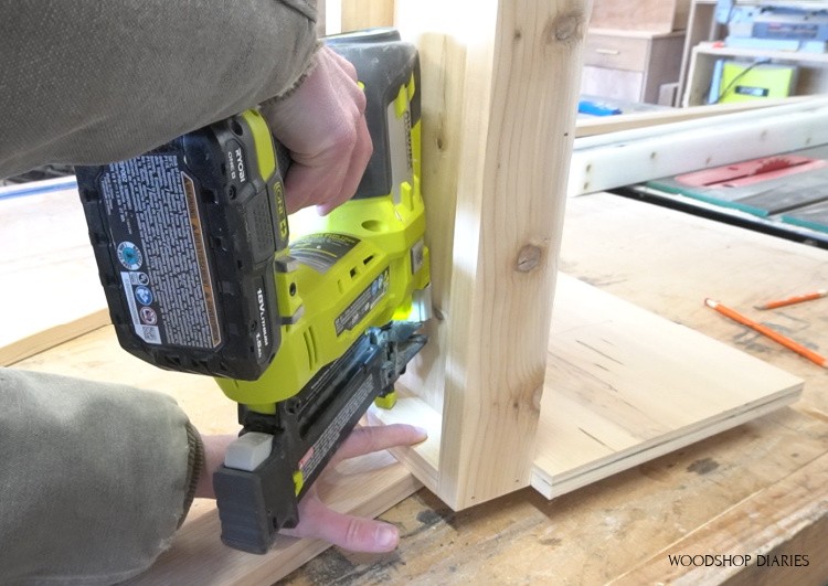 Using nail gun to secure bottom shelf to ladder sides