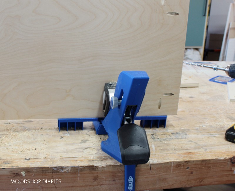 Kreg 720 pocket hole jig with support wings extended and plywood panel clamped in place