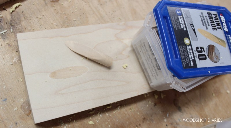 Paint grade plugs container sitting on plywood board with pocket hole filled