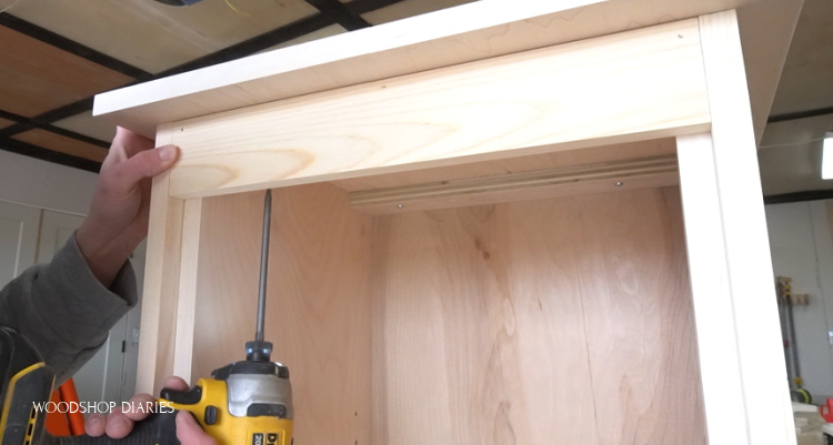 Screwing top plywood panel onto top of linen cabinet frame