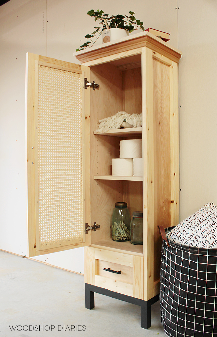 Finished DIY cane door linen cabinet or tall pantry cabinet with door open and adjustable shelves inside