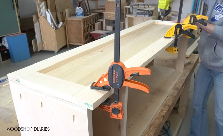 Brad nailing side panel trim onto DIY pantry cabinet