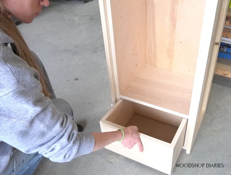 Shara Woodshop Diaries sliding small drawer into bottom of linen cabinet